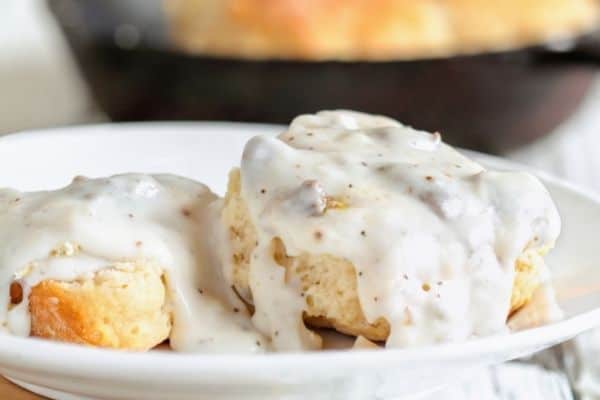 sausage gravy on biscuits on white plate