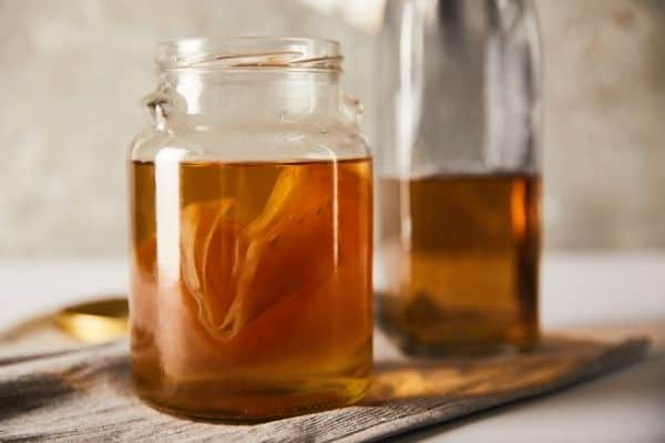 kombucha in glass jars with SCOBY for health benefits of Kombucha and does it go bad