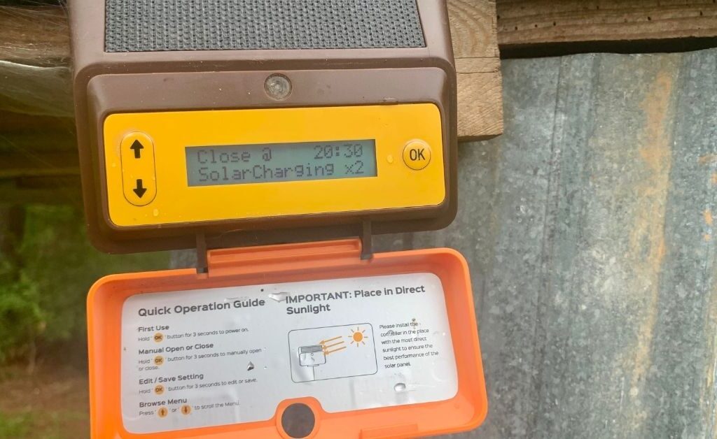 ChickCozy Automatic Chicken Coop Door remotely mounted control device open to view directions and read out.