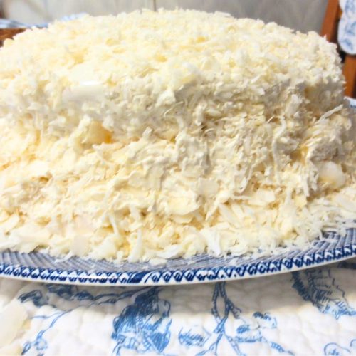 old fashioned layered coconut cake on a blue willow plate