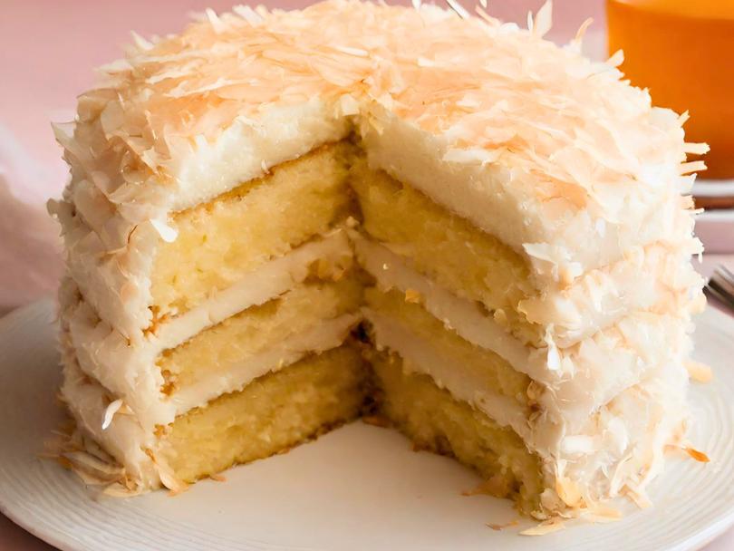 three layered old fashioned coconut cake on a white plate