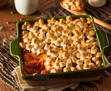 sweet potato casserole with marshmallows on top in a green casserole dish