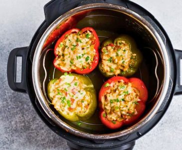 four stuffed bell peppers in an instant pot after cooking two red peppers and two green peppers