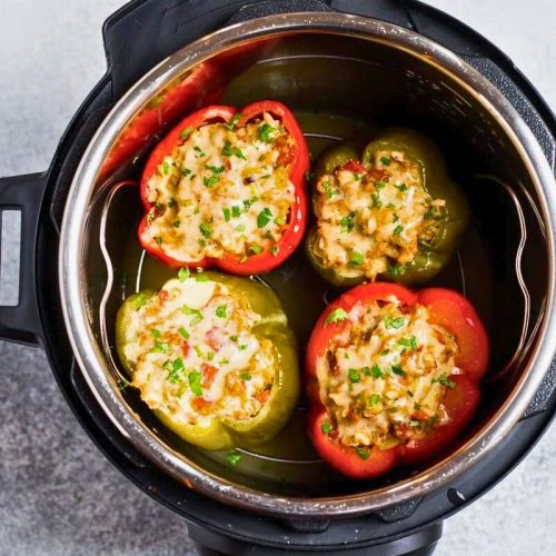 four stuffed bell peppers in an instant pot after cooking two red peppers and two green peppers