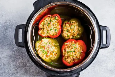 four stuffed bell peppers in an instant pot after cooking two red peppers and two green peppers