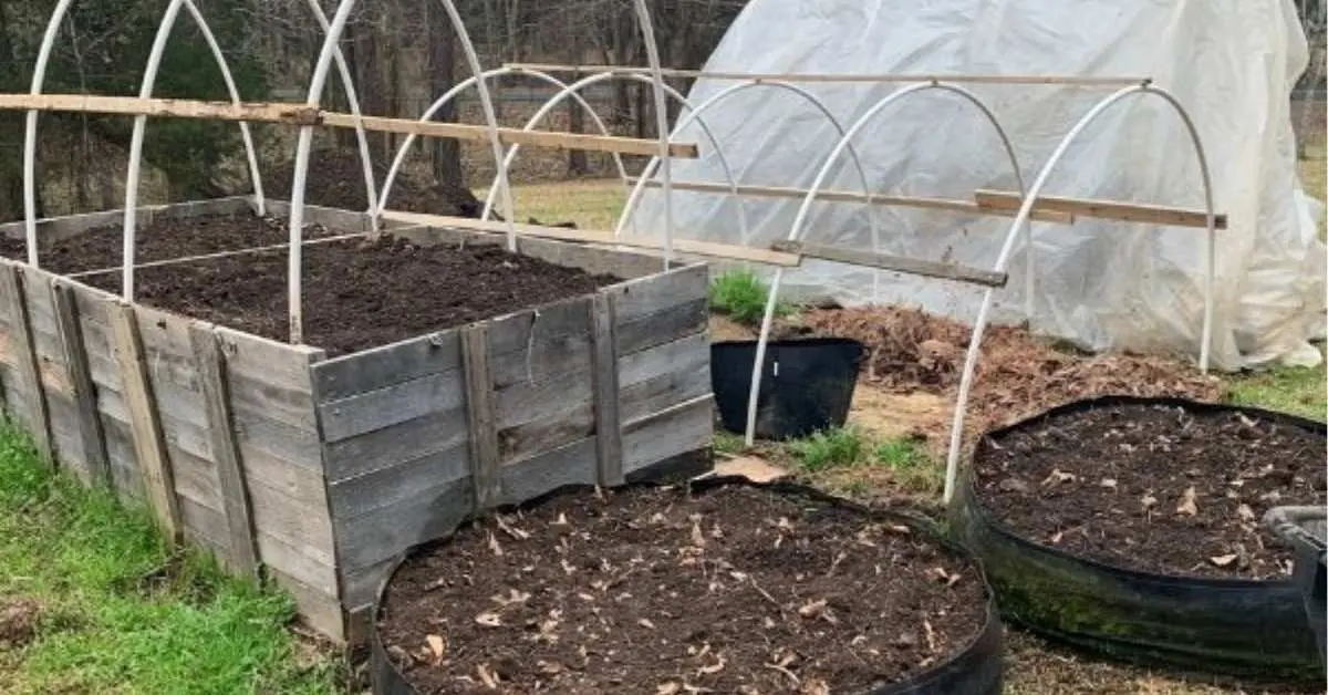 How to set up a vegetable garden - hoop house with round beds out front, waiting to be planted.