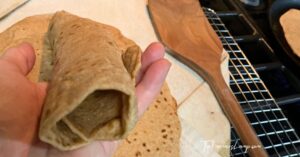 spelt flour tortillas showing one rolled in a hand