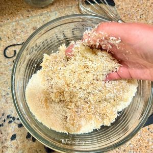 Hands working the coconut mixture in the bowl