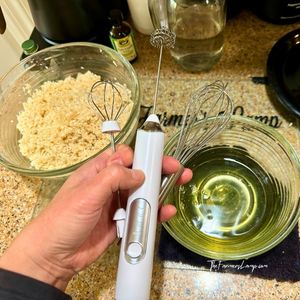 Milk frother with bowls of ingredients for gluten free coconut macaroons visible in the background.