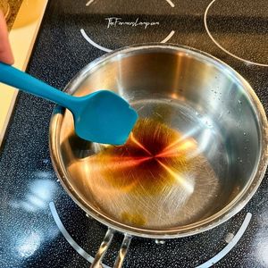 Heating water and vanilla extract in a pan on the stove.